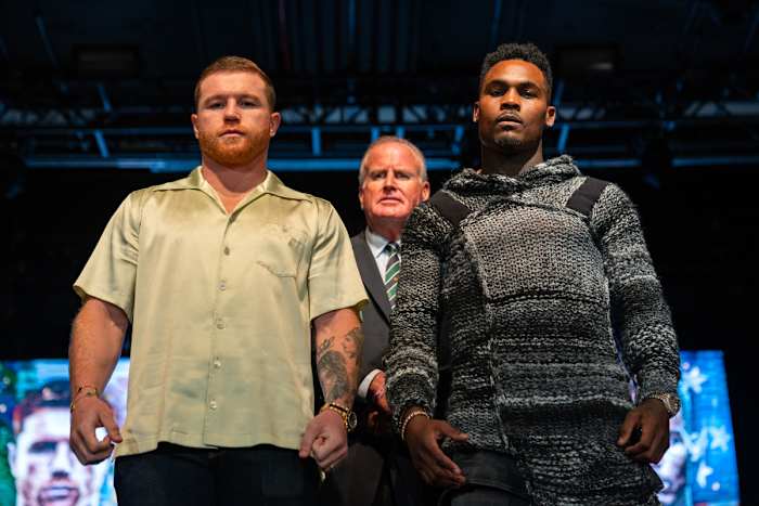 Canelo Alvarez and Jermell Charlo pose for the camera during a press conference for their boxing title fight.